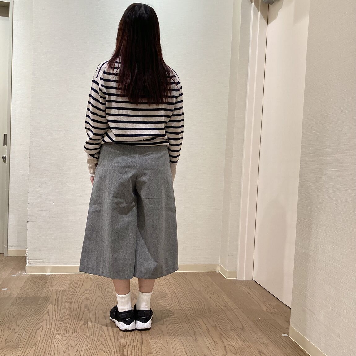 ボーダーのニットとキュロットスカートを着用した女性