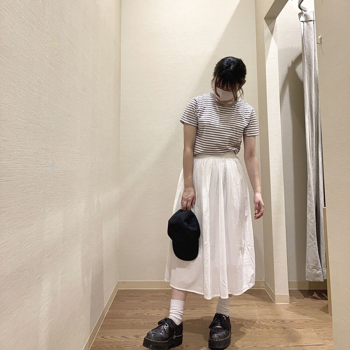 ボーダーのTシャツと白のスカートを着用した女性