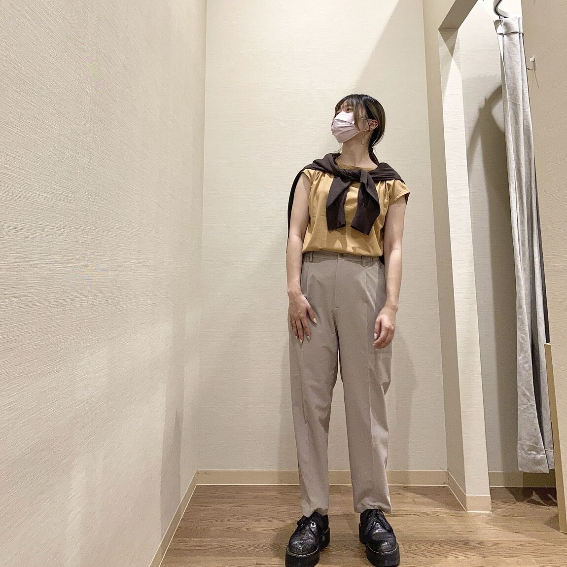 フレンチスリーブのTシャツにカーディガンを肩がけした女性