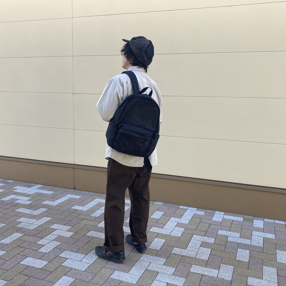 中わたリュックサックを着た男性の後ろ姿