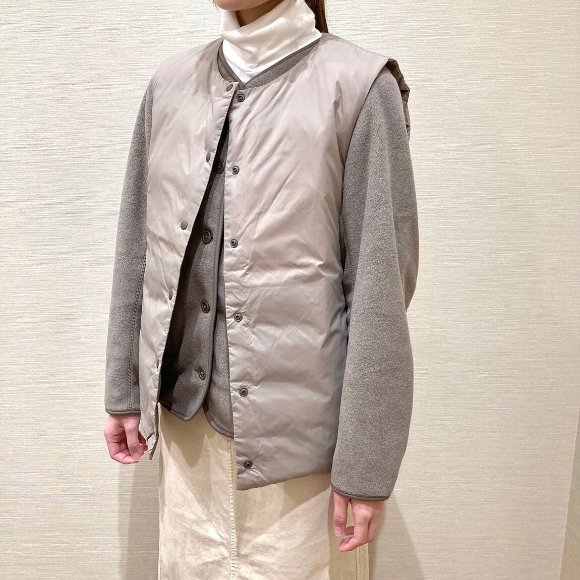 白いスカートとベージュのフリースを着用した女性