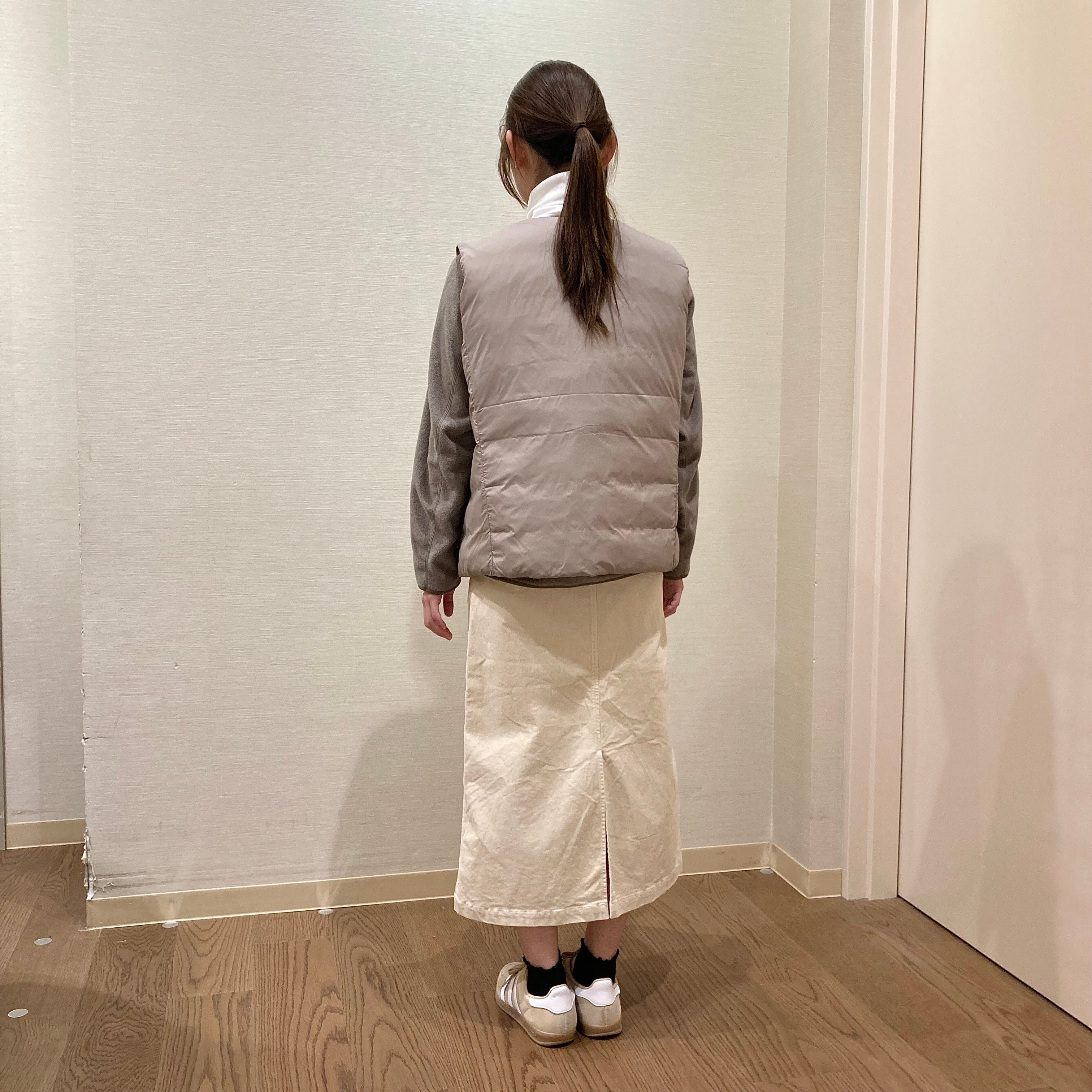 白いスカートとベージュのフリースを着用した女性