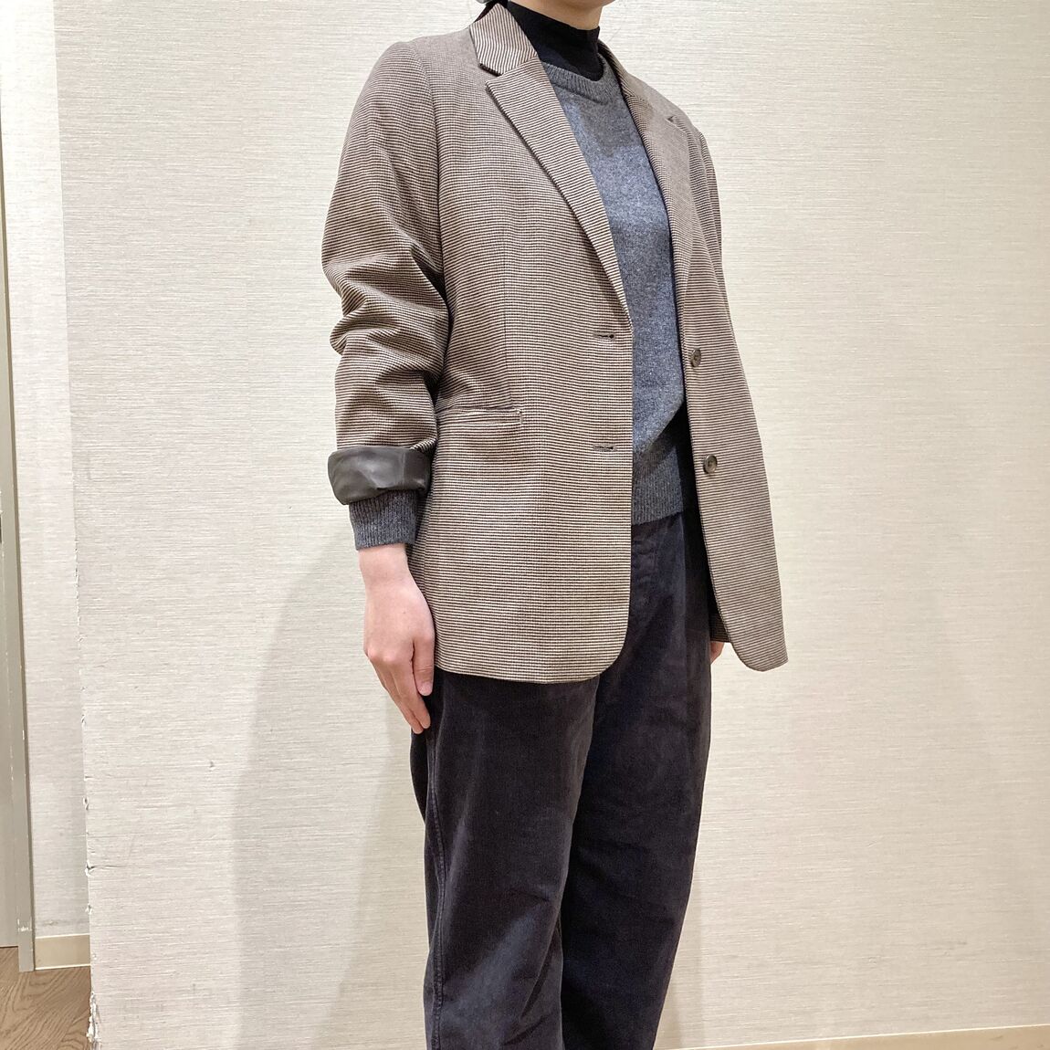 ブラウンのテーラードジャケットを着用した女性