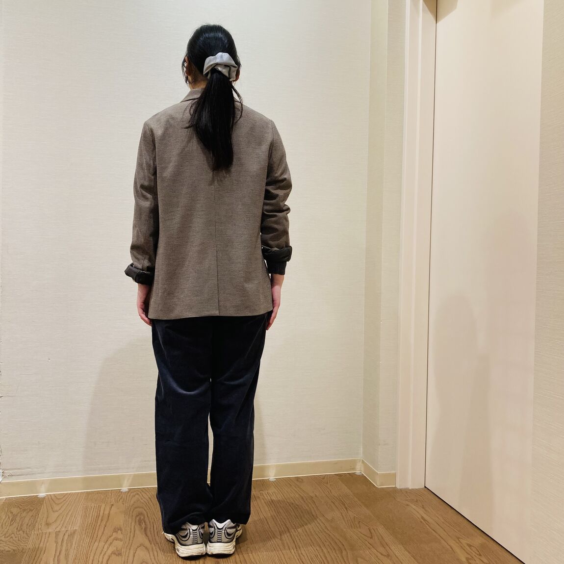 ブラウンのテーラードジャケットを着用した女性