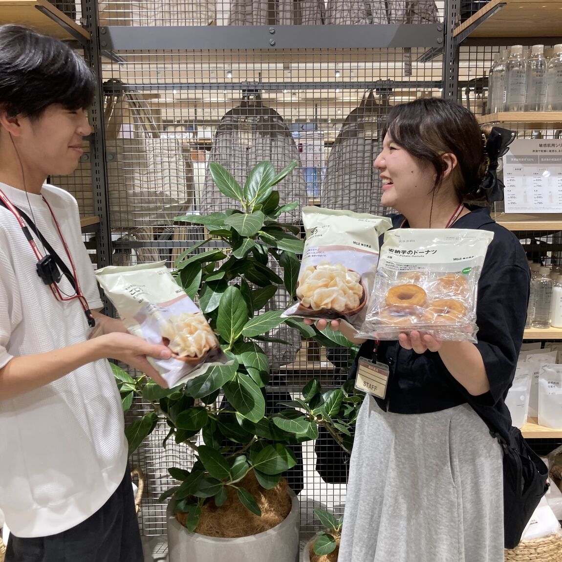 ごぼうスナックとドーナツを持つスタッフ2人