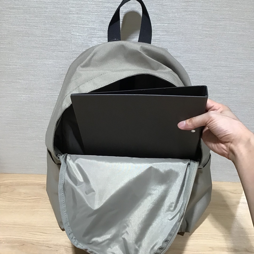 リュクサックのメインポケットに物を入れている写真