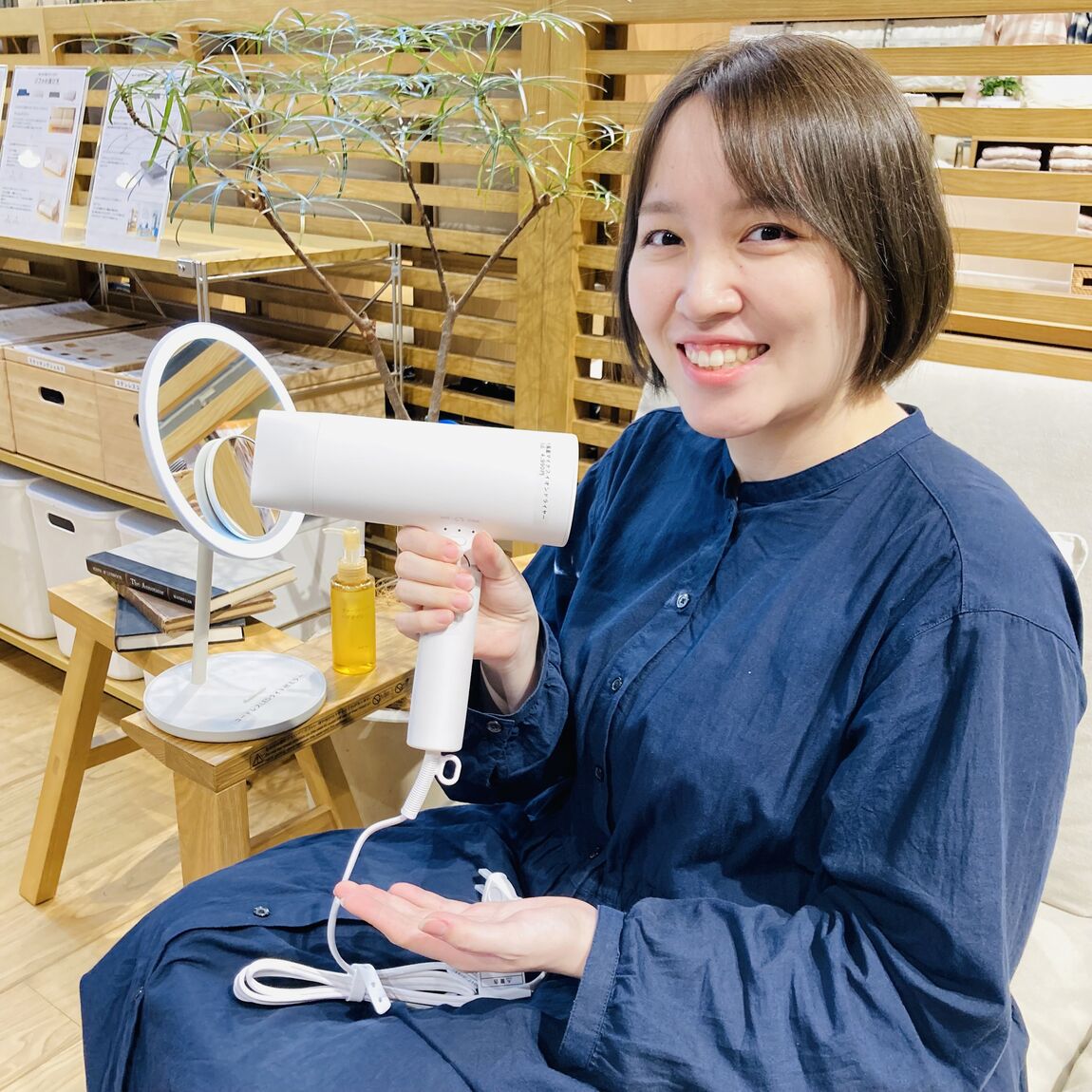 スタッフがドライヤーを持ちにこやかに笑っている写真