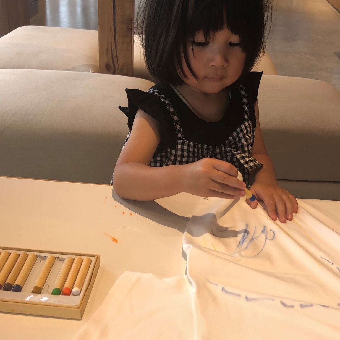 子供がTシャツに絵を描いている写真