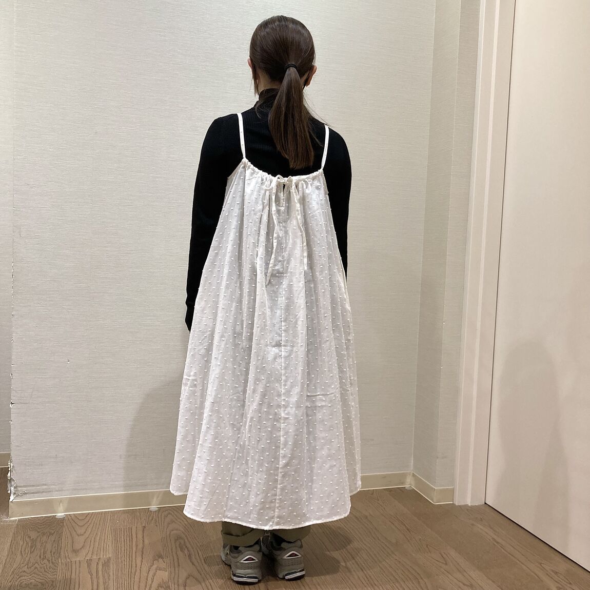 白いキャミワンピースを着用した女性