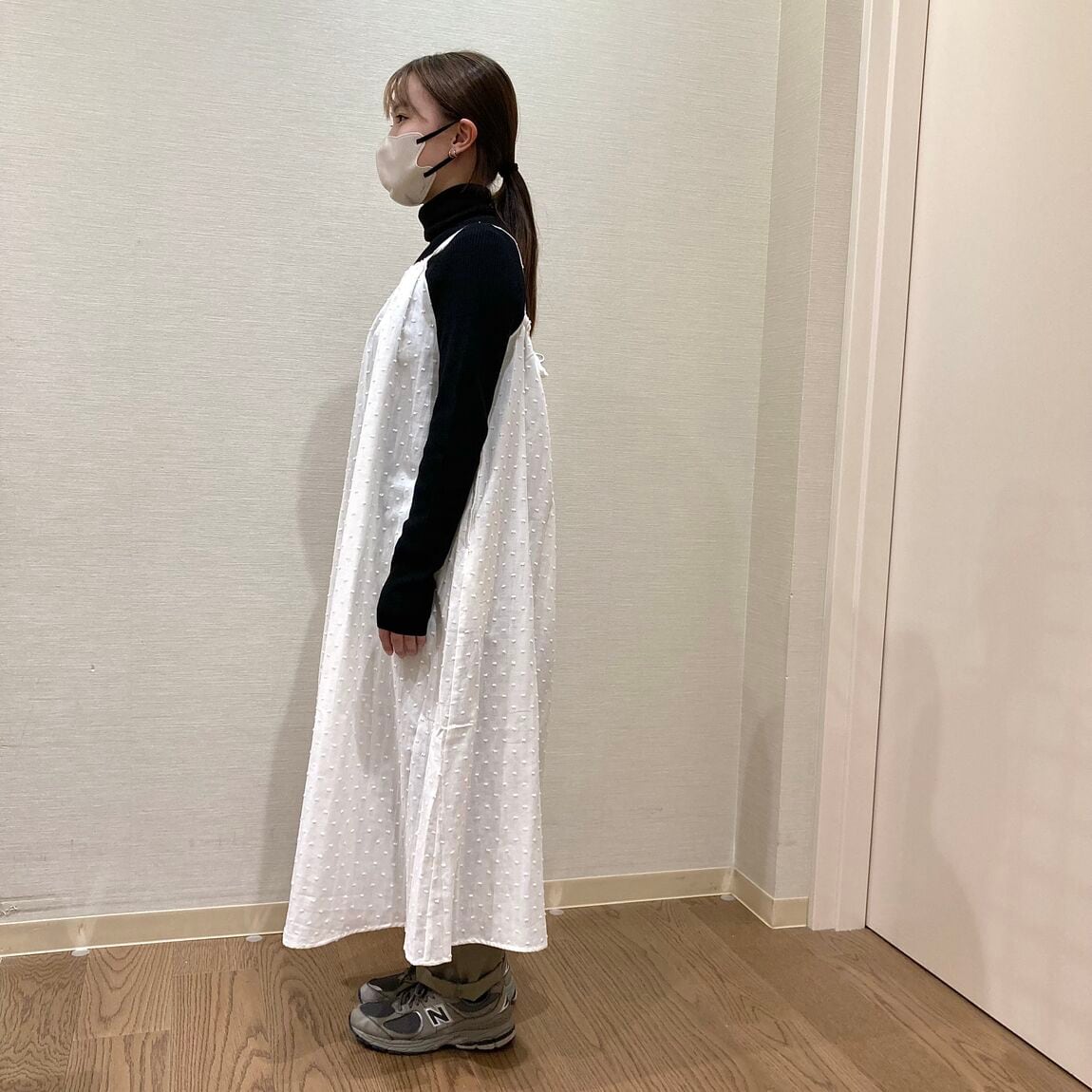 白いキャミワンピースを着用した女性