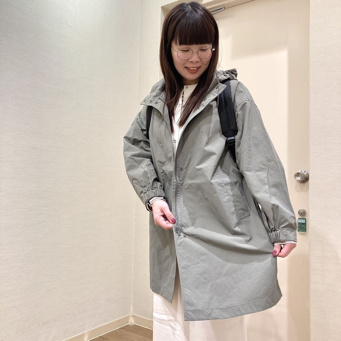 カーキのロングジャケットを着用した女性