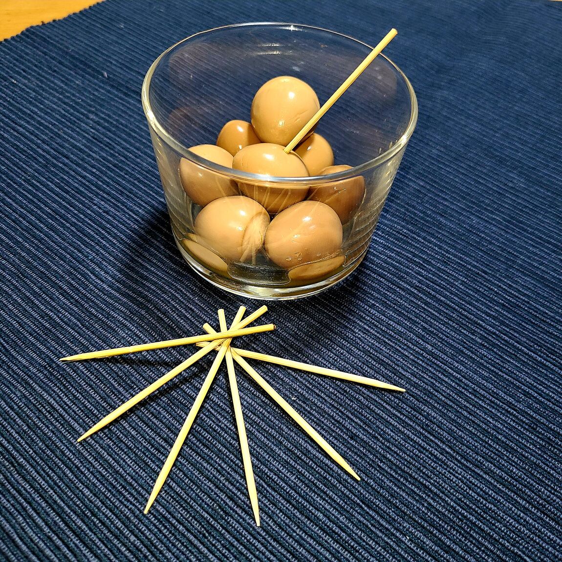 うずらのたまごをグラスに盛り付けて楊枝を刺した画像です。