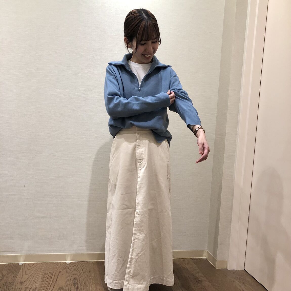 青いセーターと白いスカートを着用した女性