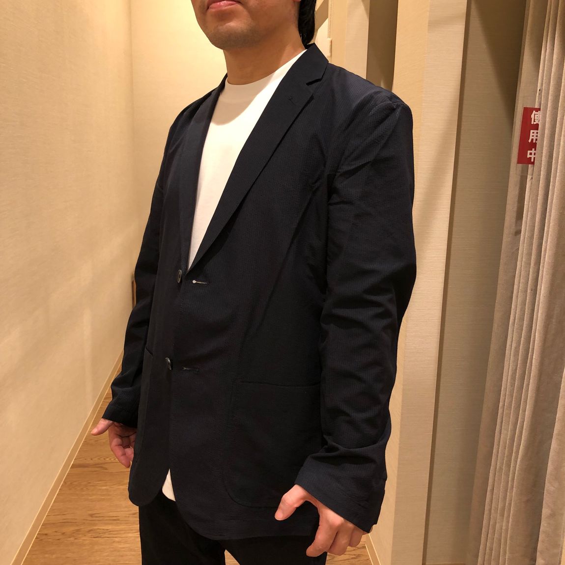 ジャケットとパンツのセットアップを着用した男性
