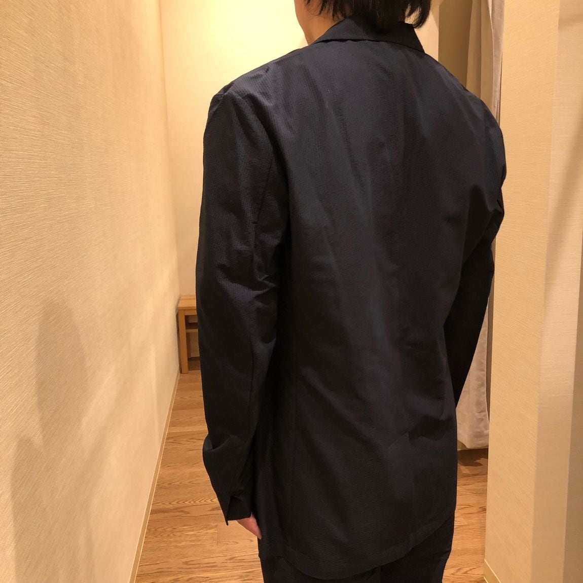 ジャケットとパンツのセットアップを着用した男性