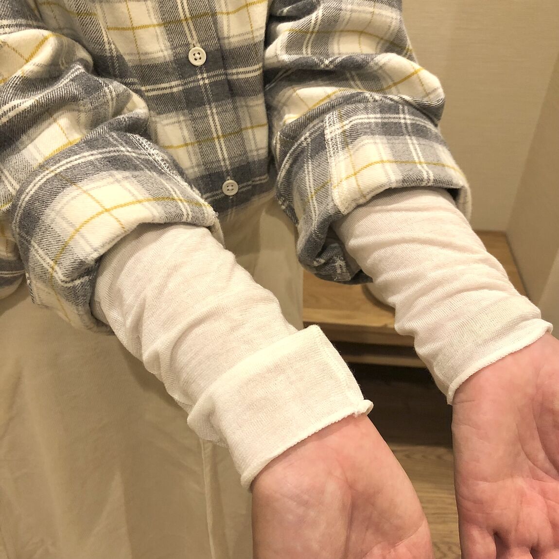 チェックのシャツと白いスカートを着た女性