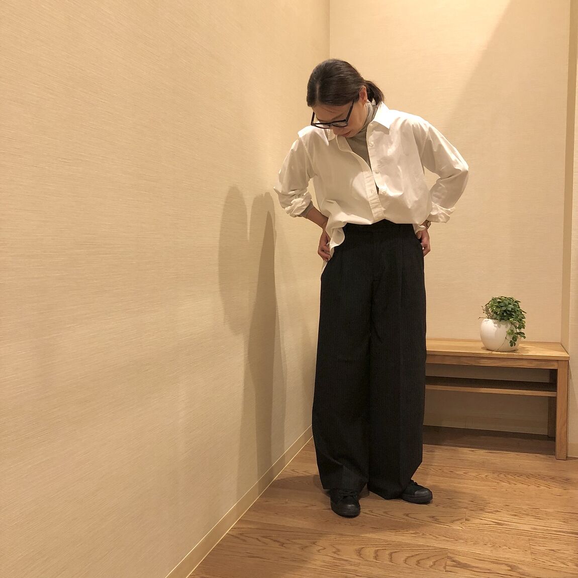 白いシャツとワイドパンツを着た女性