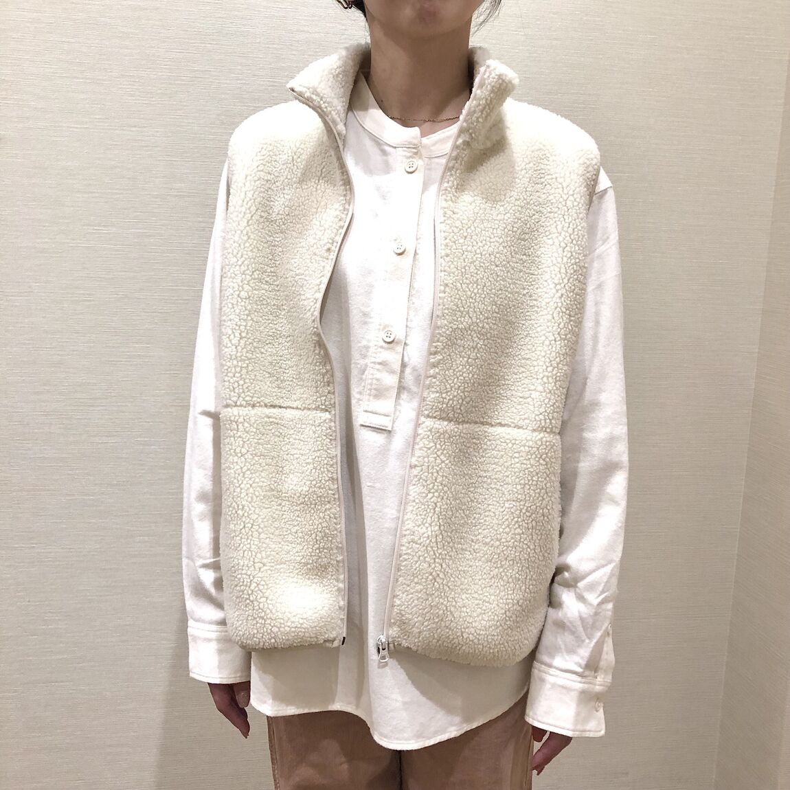 白いボアフリースベストを着用した女性