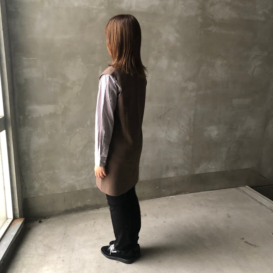 ベストを着た女性の後ろ姿