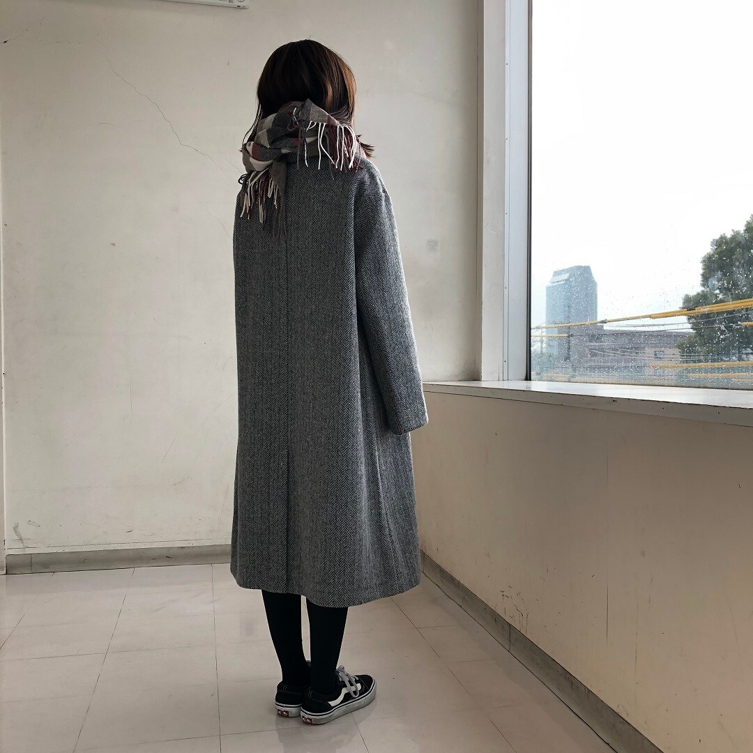 女性スタッフがコートをきた後姿の写真