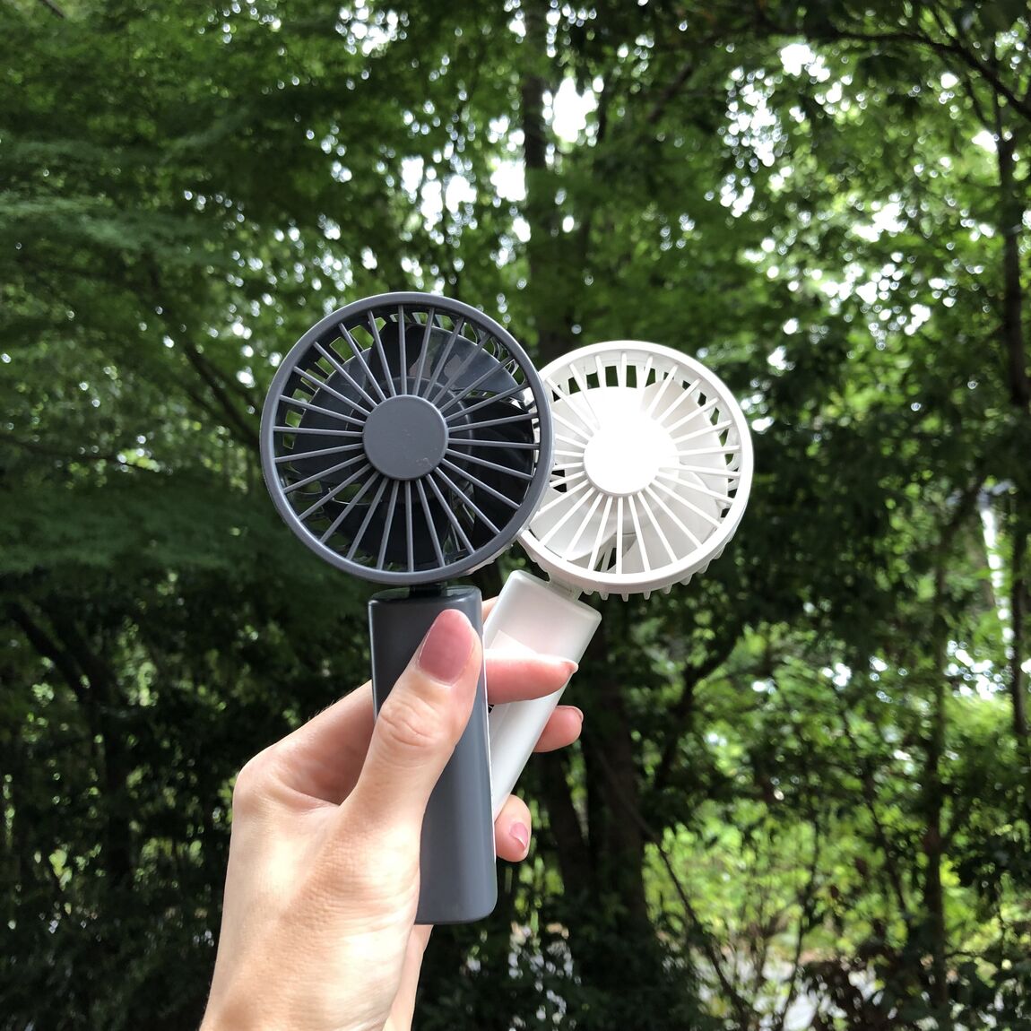 充電式コンパクトハンディファンを持っている写真