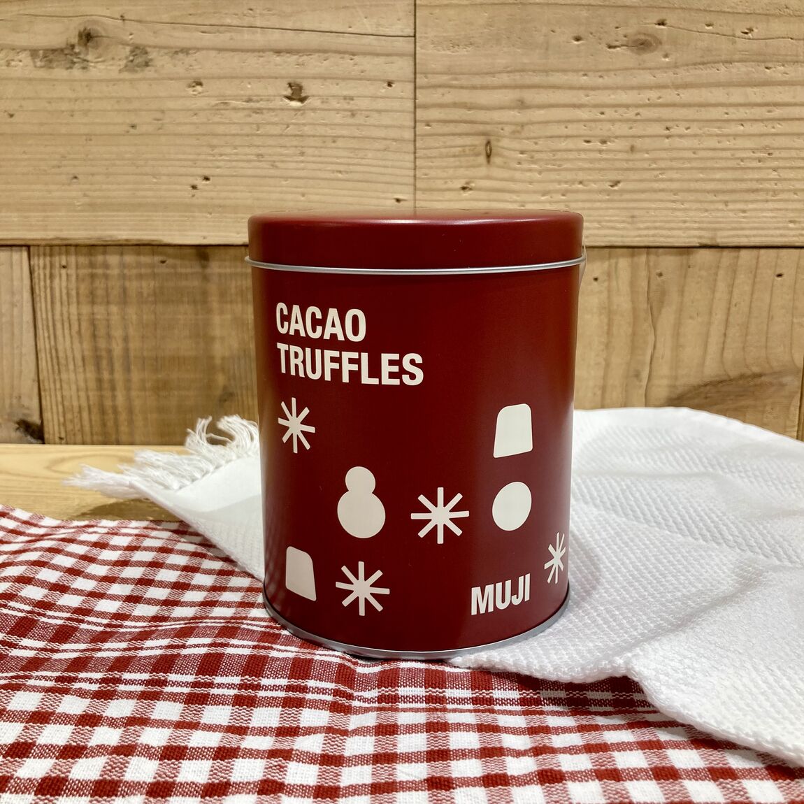 ギフト缶カカオトリュフカカオニブの写真、赤い缶に白で雪だるまやカカオトリュフのデザインが施されてます。