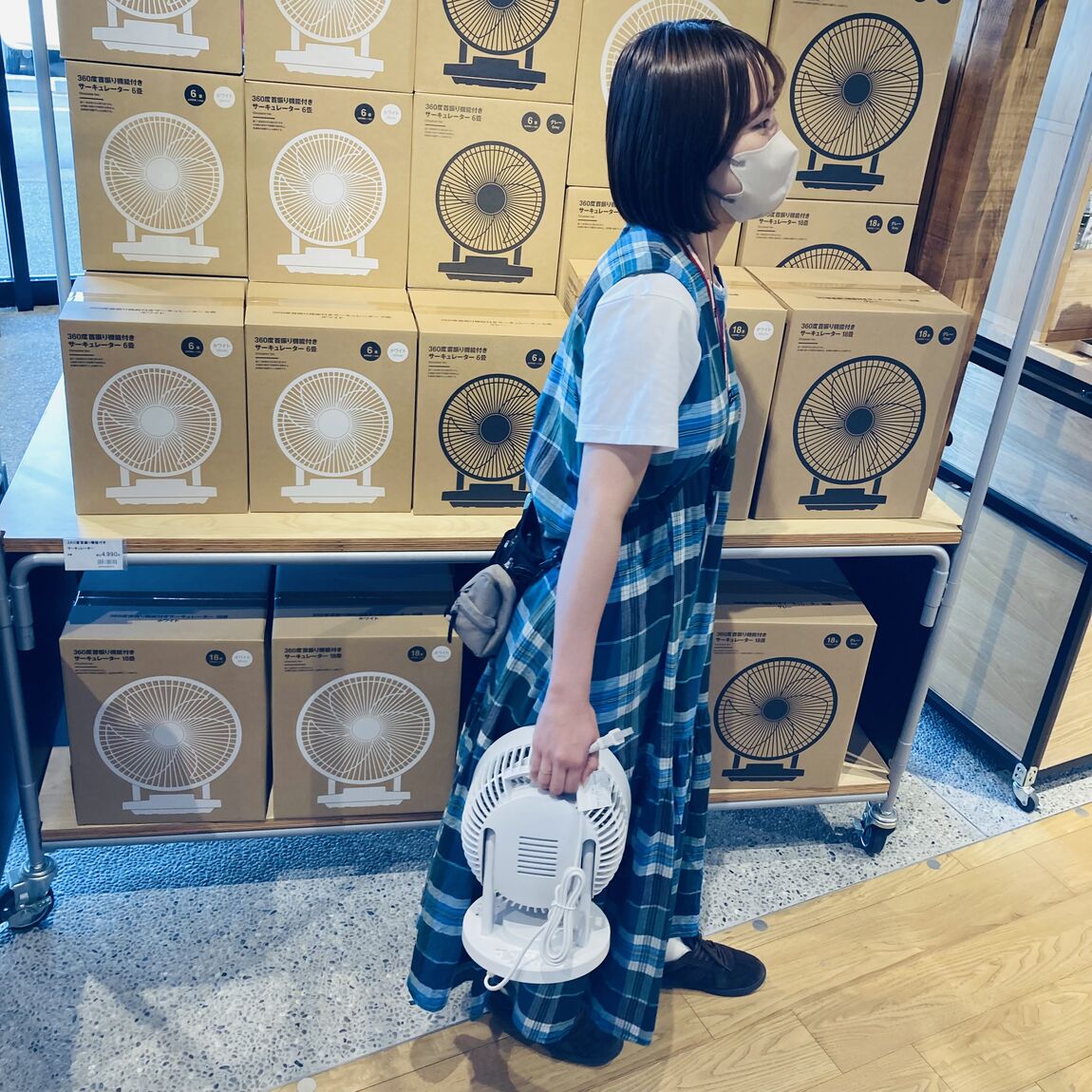 サーキュレーターを持ち運びしているスタッフ