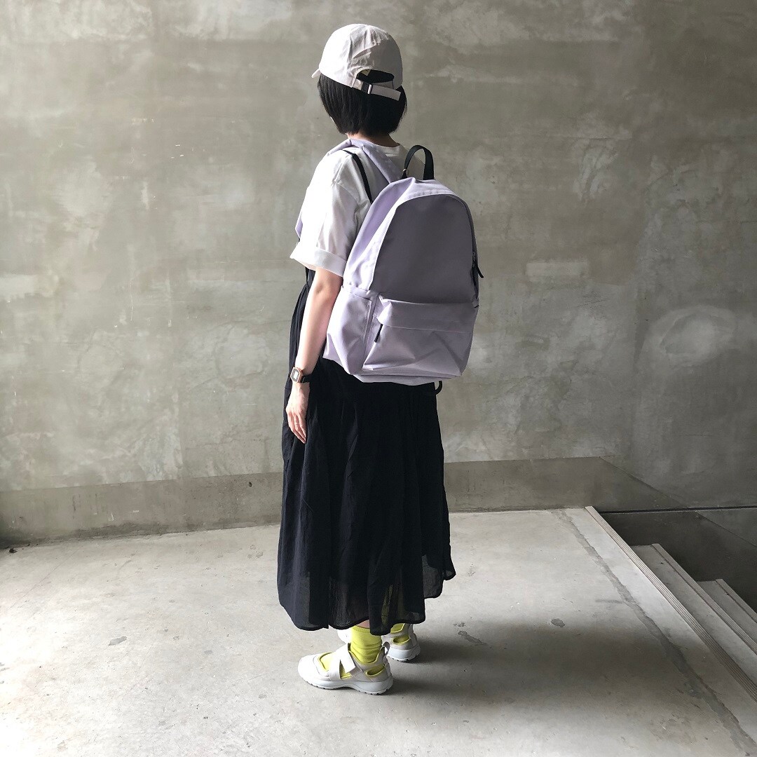 リュックサックを背負った女性スタッフ