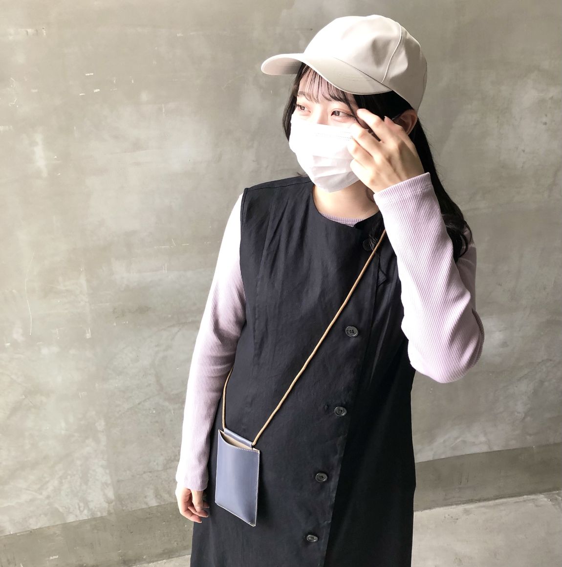 帽子に手をそえる女性スタッフ