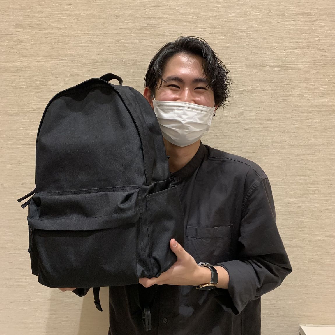リュックサックとスタッフの笑顔の写真