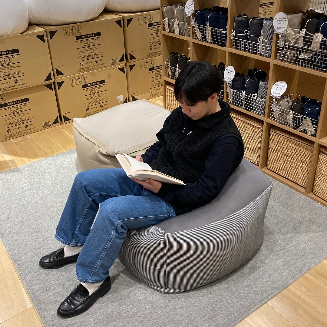 体にフィットするソファに座る男性の写真