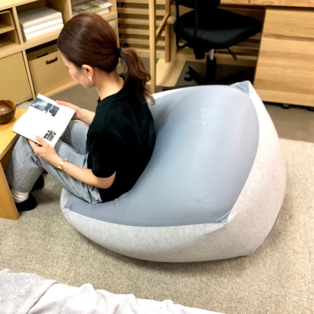 体にフィットするソファで読書する画像