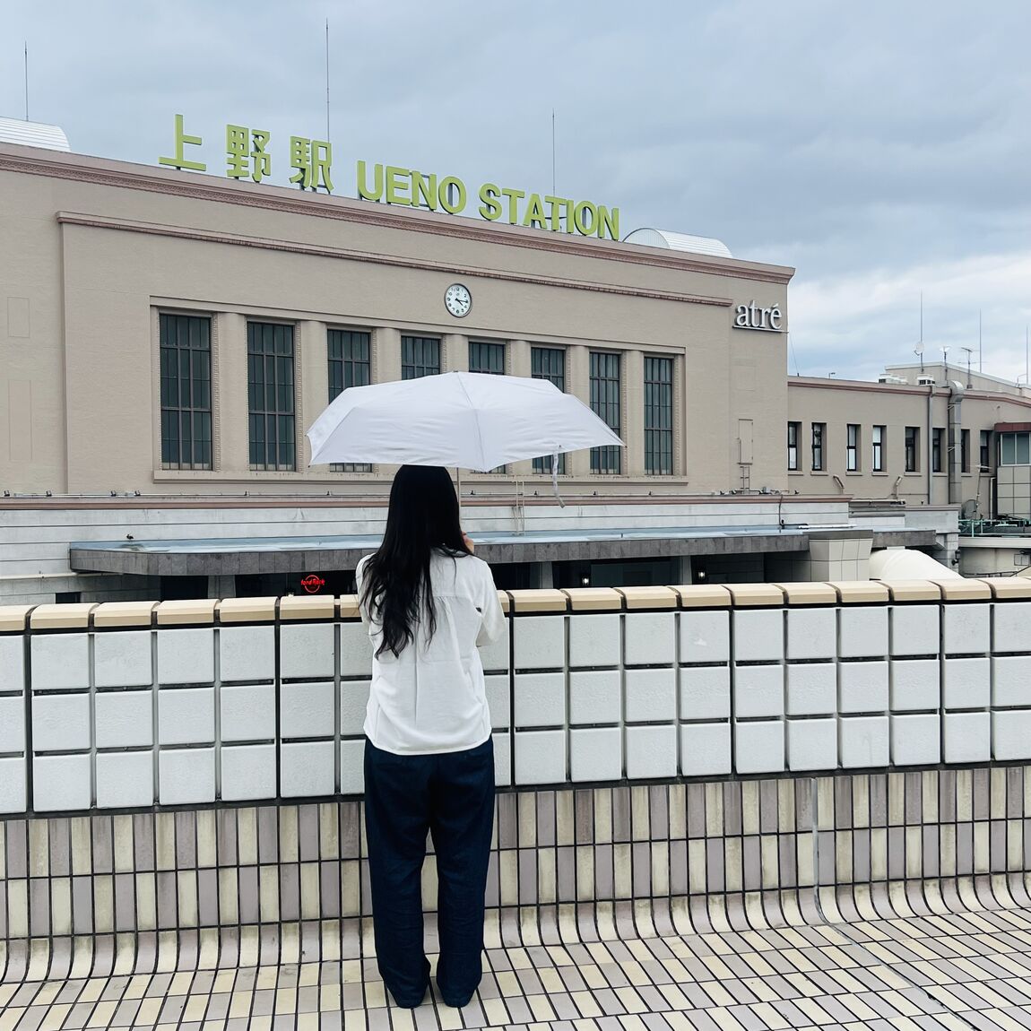 傘を持つスタッフの後ろ姿