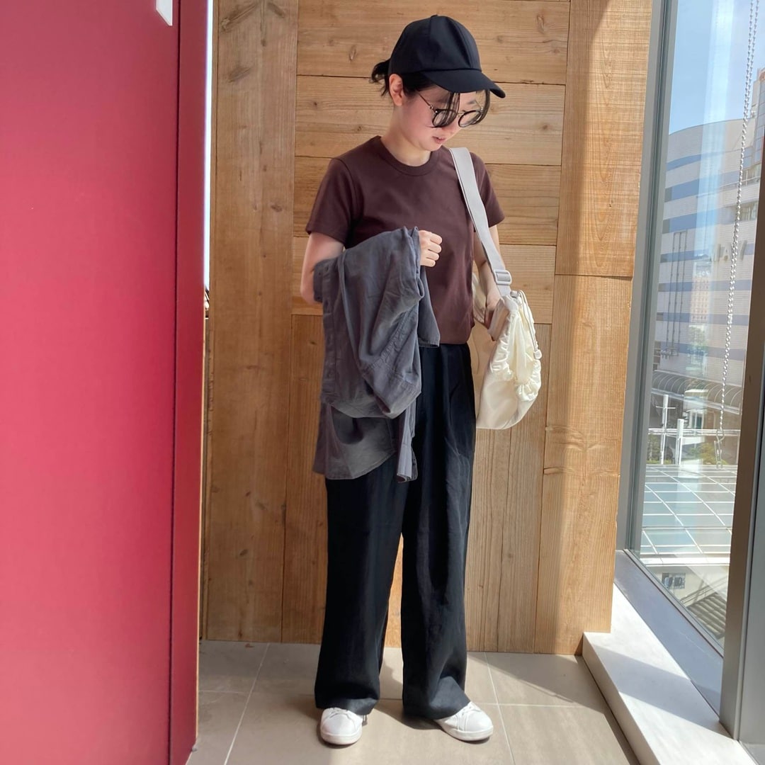 半袖Tシャツを着て長袖シャツを持っている女性