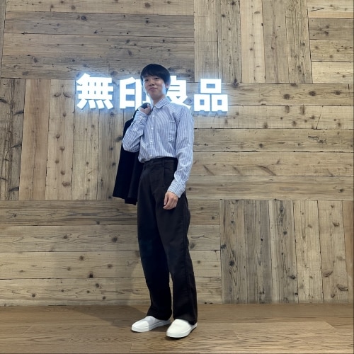 上着を肩にかけた男性の画像