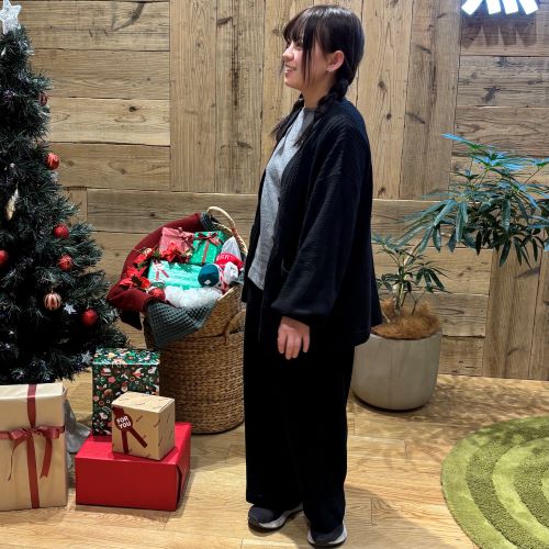 黒のセットアップのルームウェアを着て立つ女性