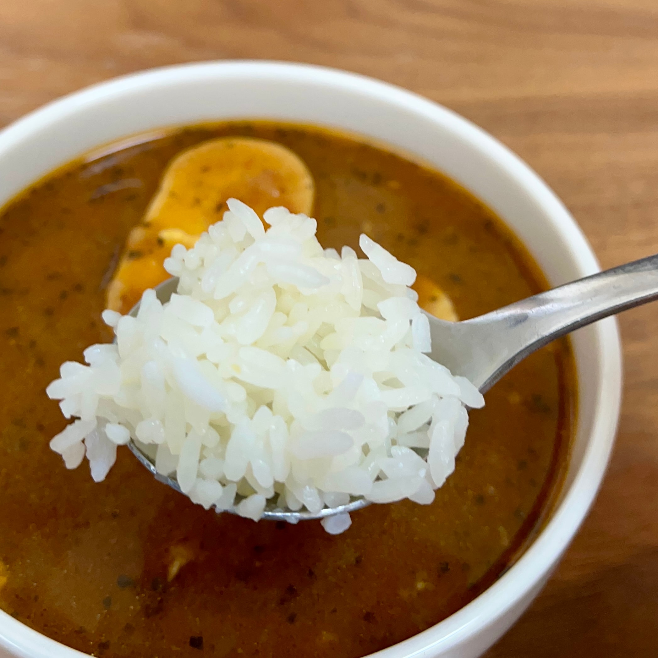 カレーが背景でお米(スプーン)が写っている写真