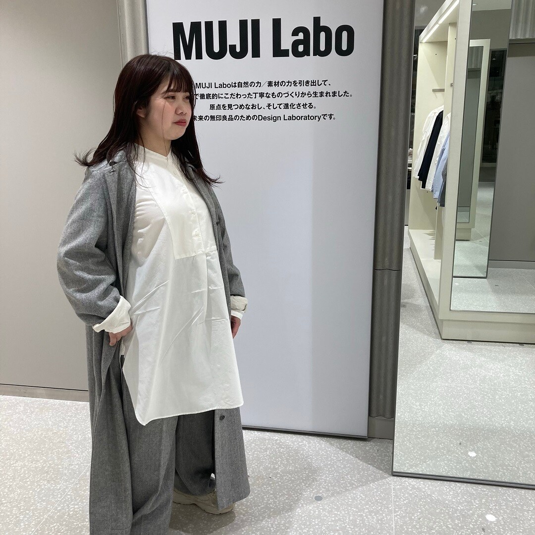 チュニックが見えるようにコートを開いているスタッフの写真