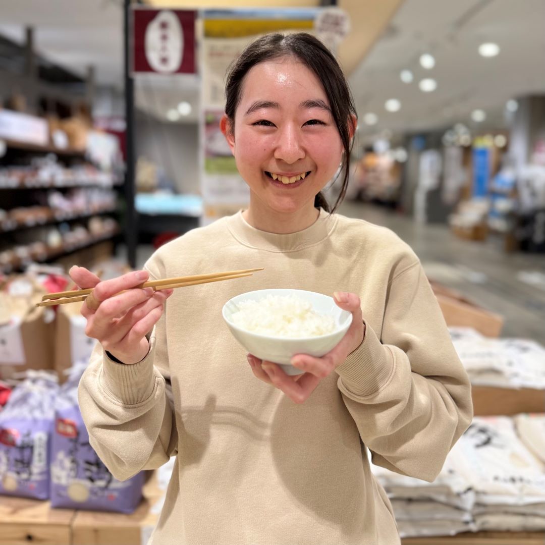 新米が盛られた茶碗を持つスタッフ