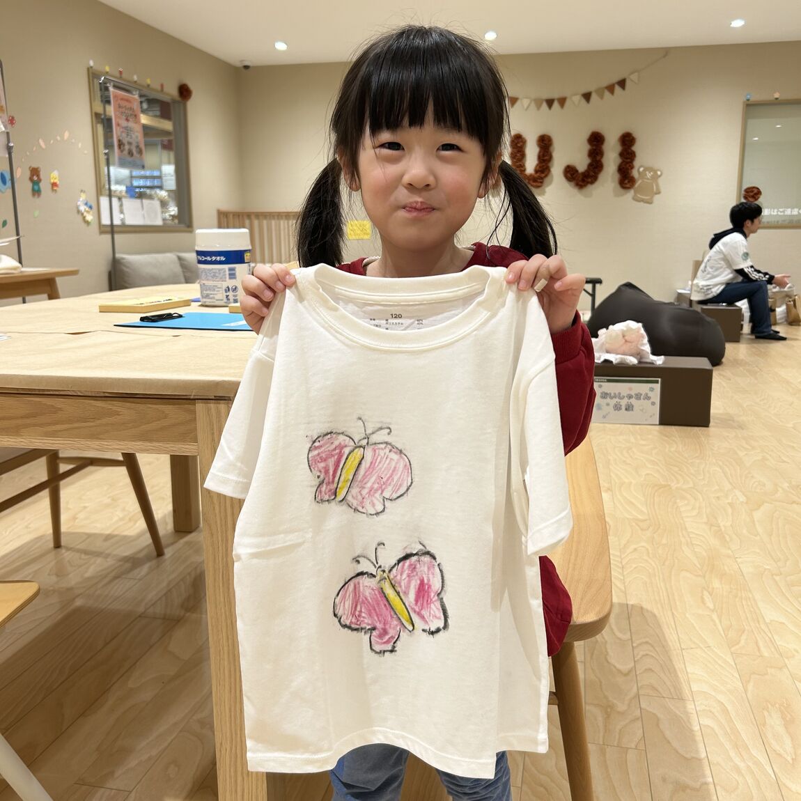 子供がTシャツを持っている様子