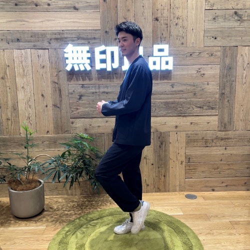 ネイビーのセットアップを着て走るようなポーズで立つ男性