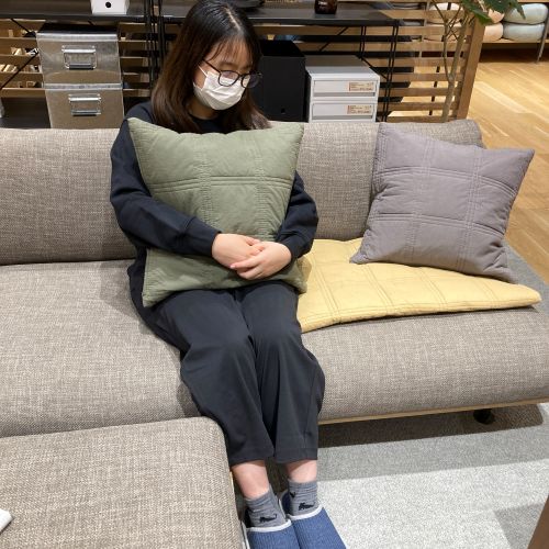 無印良品の衣服を着用している女性が椅子に座っている写真