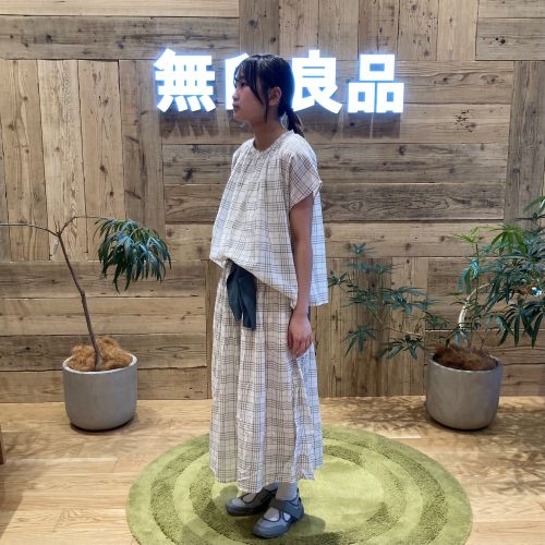 チェックのセットアップを着て横を向いて立つ女性
