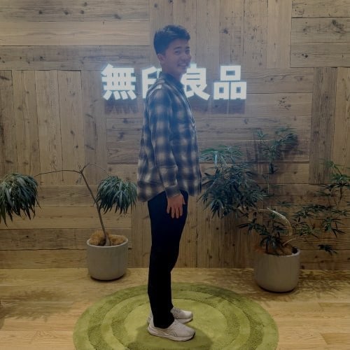 無印良品のフランネルシャツを着て立つ男性