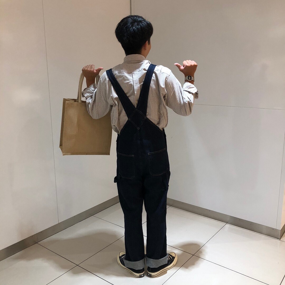 オーバーオールを着た男性が立っている写真