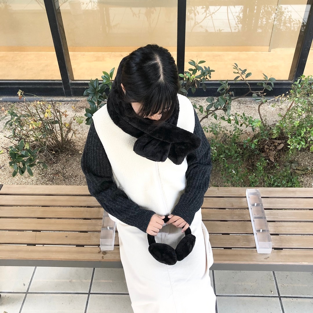 白いスカートを履いた女性がベンチに座っている写真