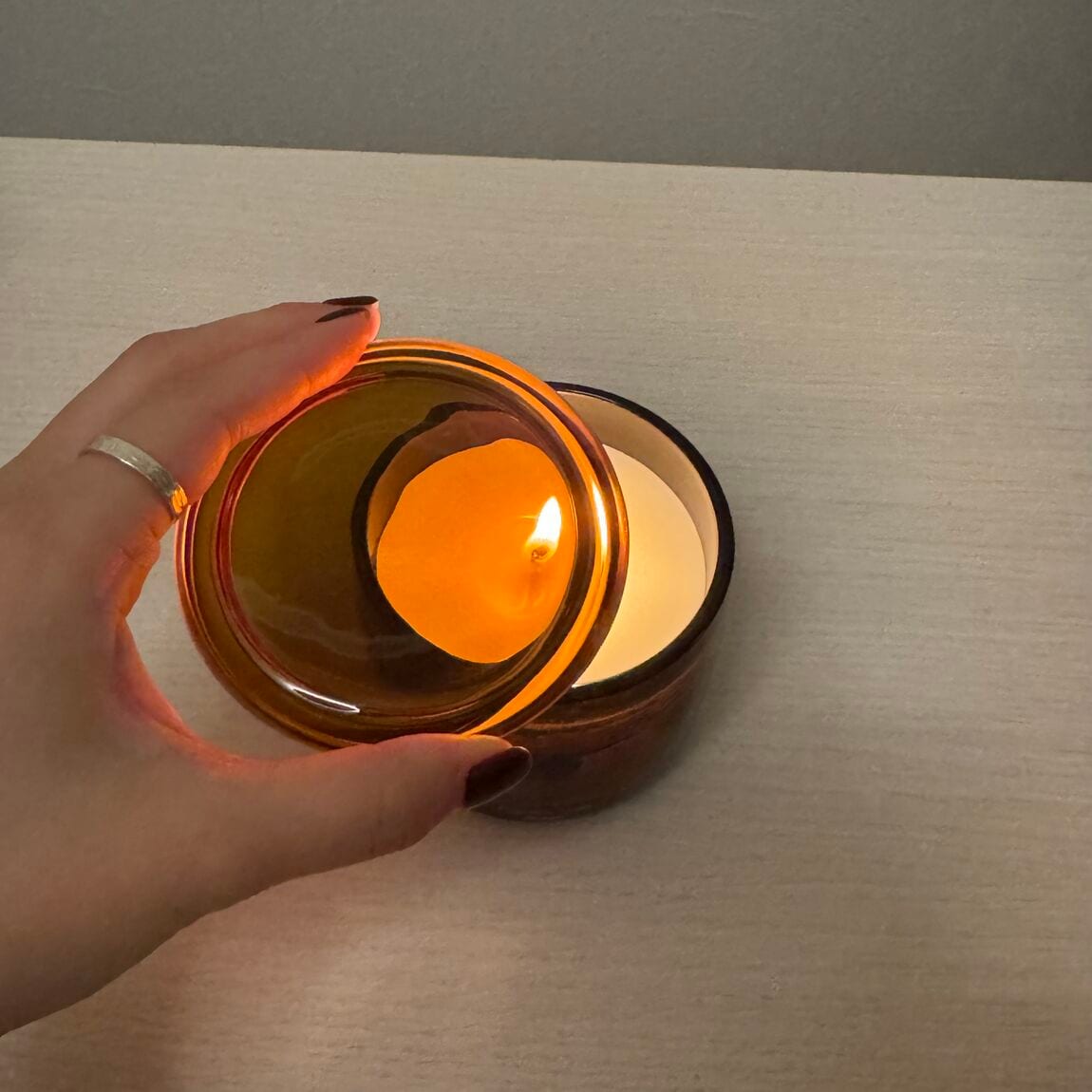 フレグランスキャンドルの蓋を被せる様子。