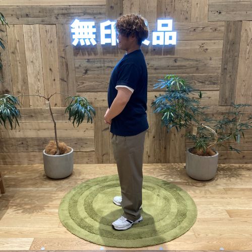 ネイビーのTシャツを着て横を向いて立つ男性