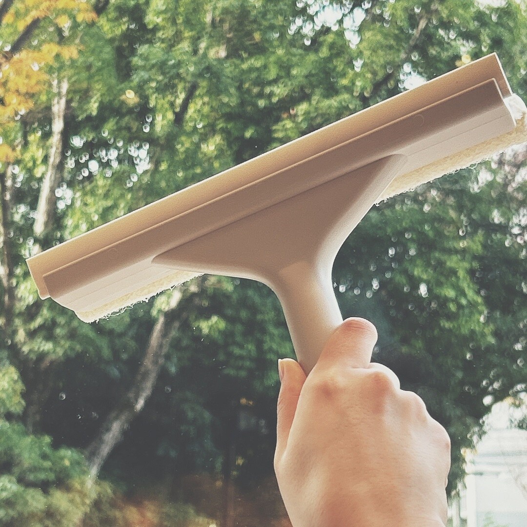 スキージーで窓を掃除している様子