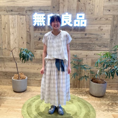 チェックのセットアップを着て正面を向いて立つ女性